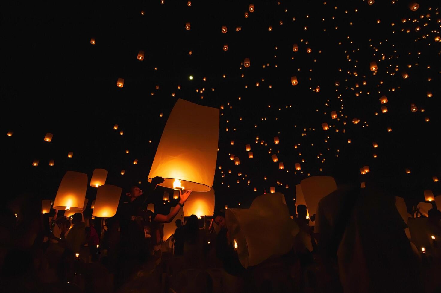 Chiang Mai - Thailand November 27, 2023 Tourists happily celebrate releasing lanterns at the Loi Krathong Yi Peng Lantern Festival according to Thai cultural traditions. photo