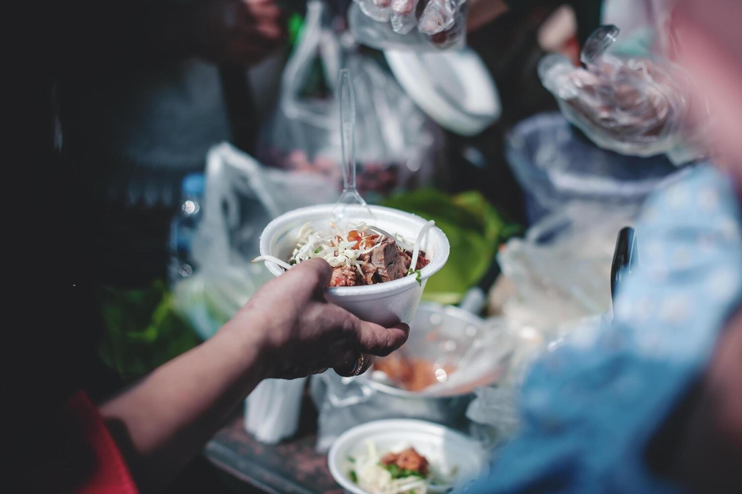 Feeding concept Homeless people offer free food from outdoor volunteers. photo