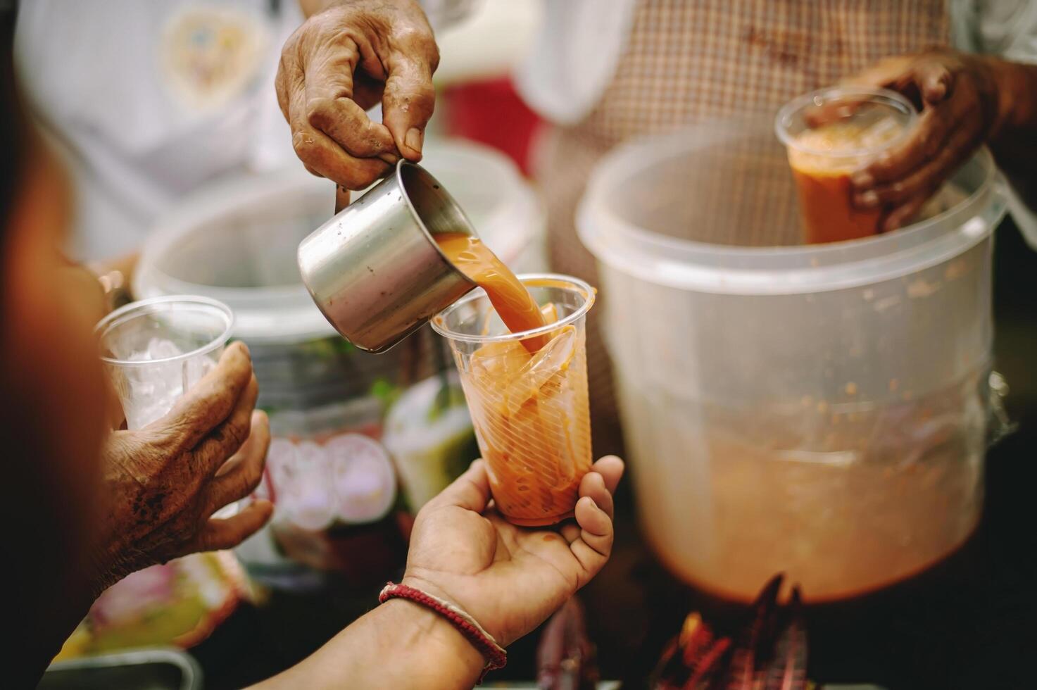 Homeless people reach out to receive free food that volunteers bring. to help alleviate hunger photo