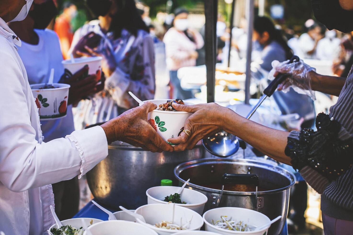 Volunteers serving hot meals to hungry migrants humanitarian aid concept. photo