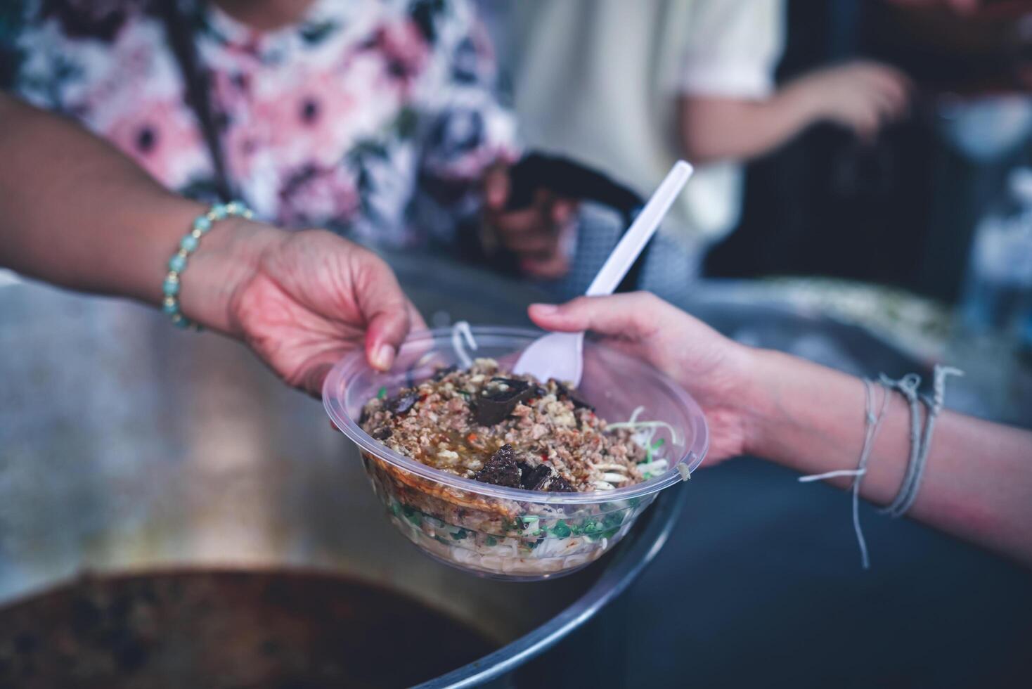 Hands of hungry people asking for free food from volunteers humanitarian aid concept photo