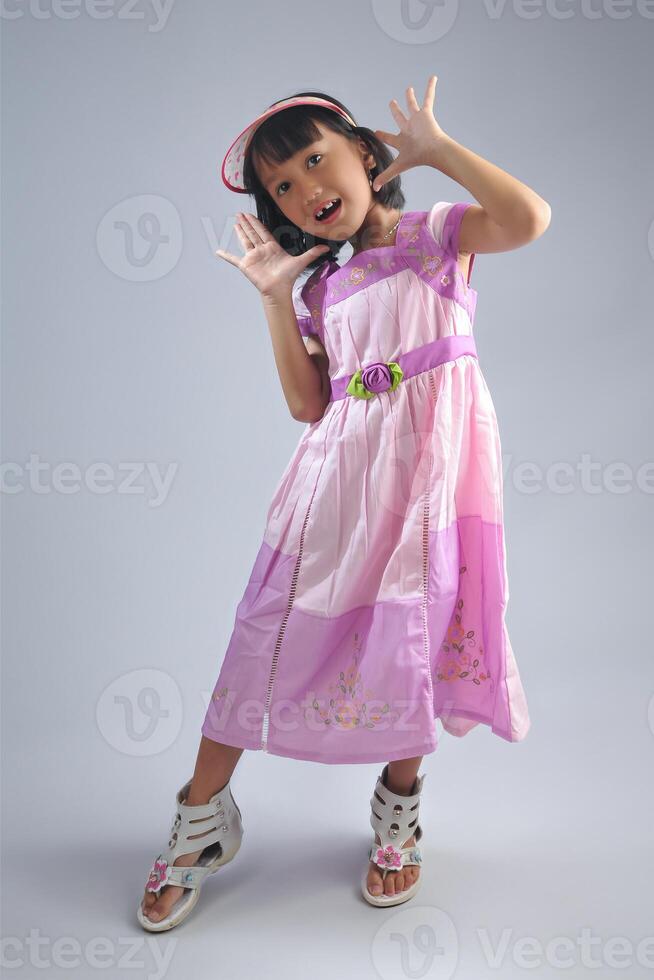 an indonesian little girl wearing fashionable dress with modeling pose. photo