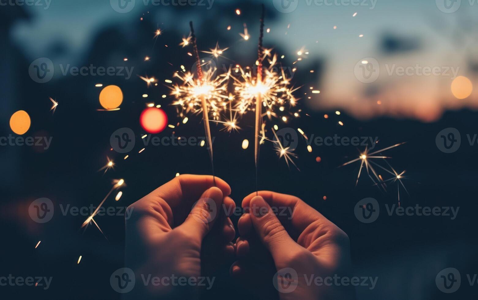 Sparklers in hands against a background of a night sky photo