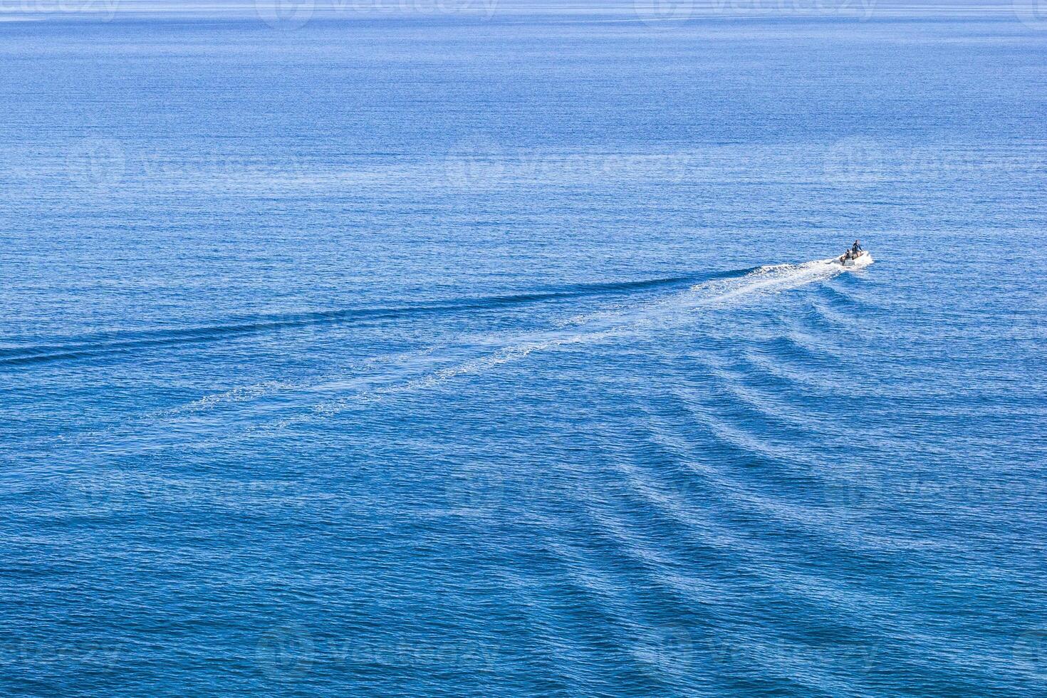 Aerial view of a tiny speedboat on a clear blue sea with waves. Mediterranean sea, Cirali, Antalya Province in Turkey. photo