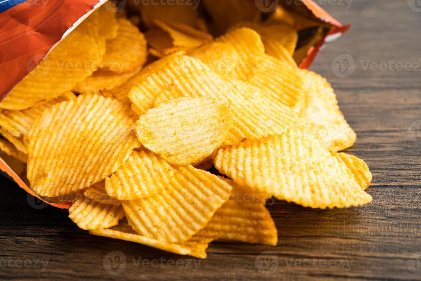 Potato chips, delicious BBQ seasoning spicy for crips, thin slice deep fried snack fast food in open bag. photo