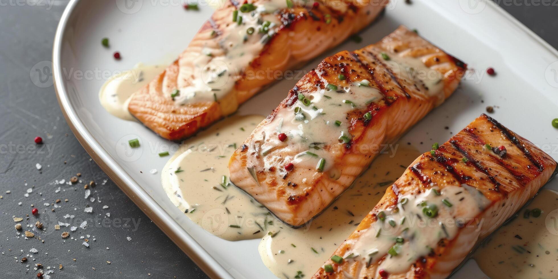 Slices of Grilled Salmon Drizzled with Creamy Mustard Chive Sauce, Artfully Presented on a White Plate photo