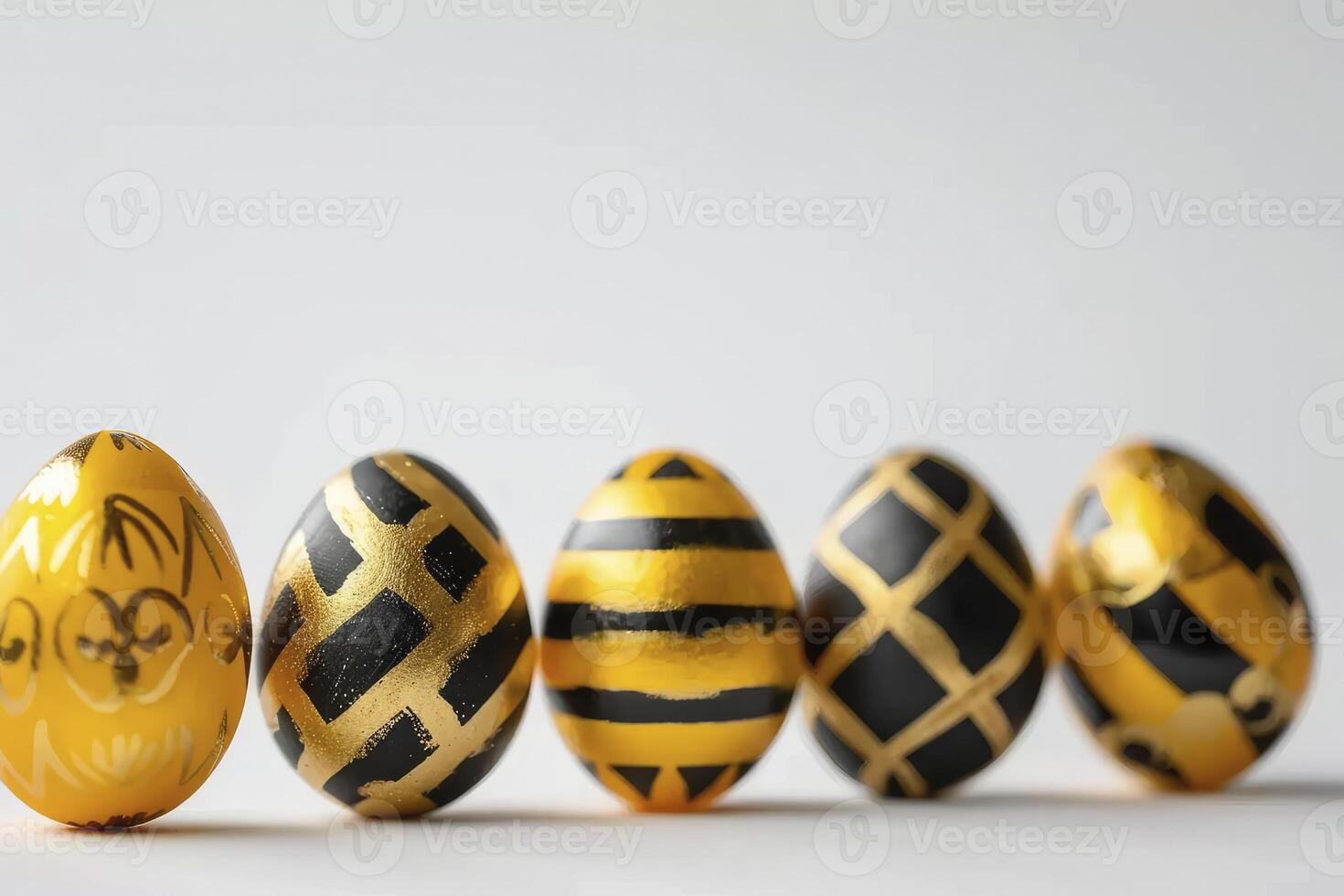 Easter golden and black decorated eggs stand in a row on white background photo