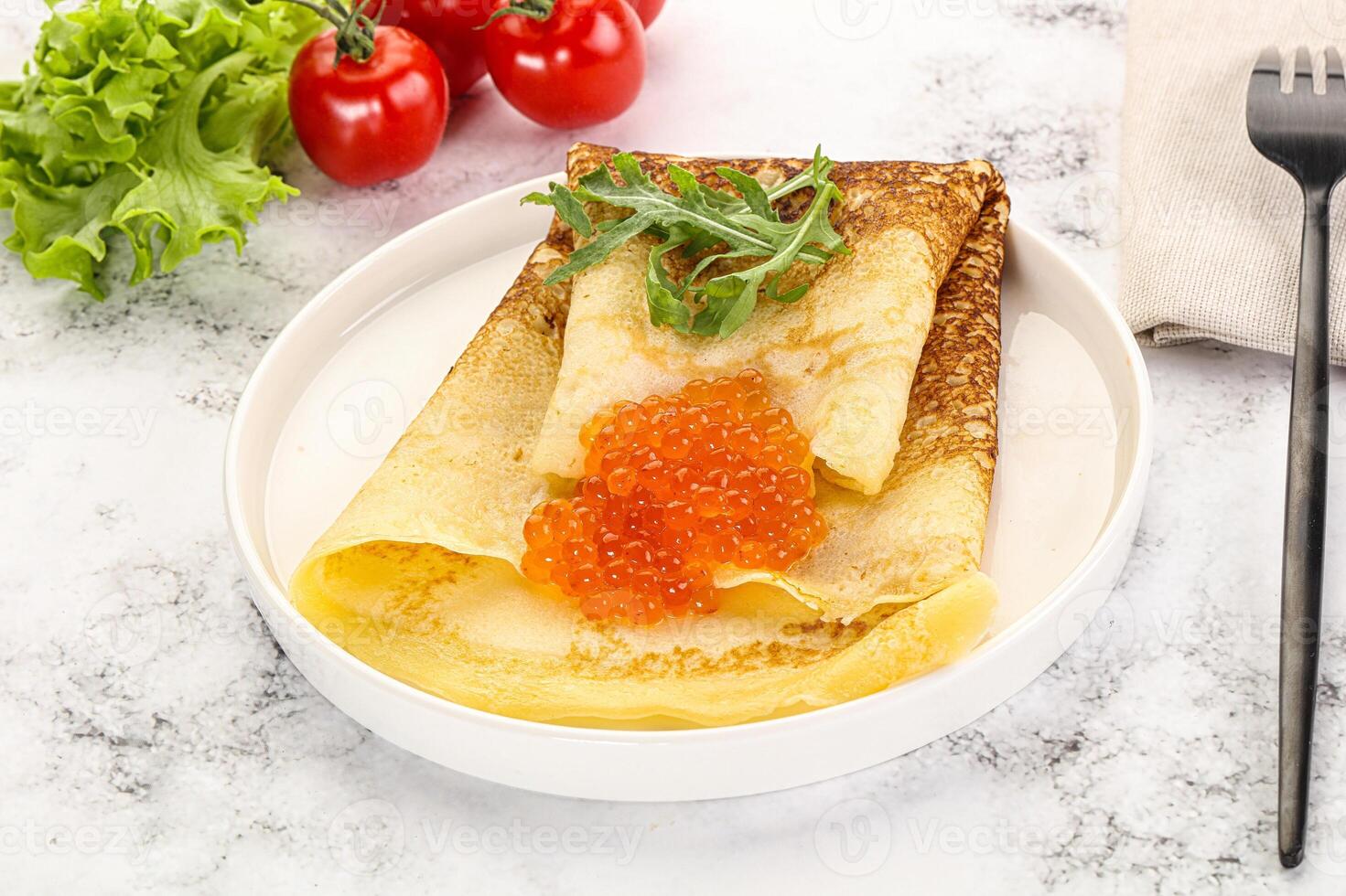 Russian pancake with red caviar photo