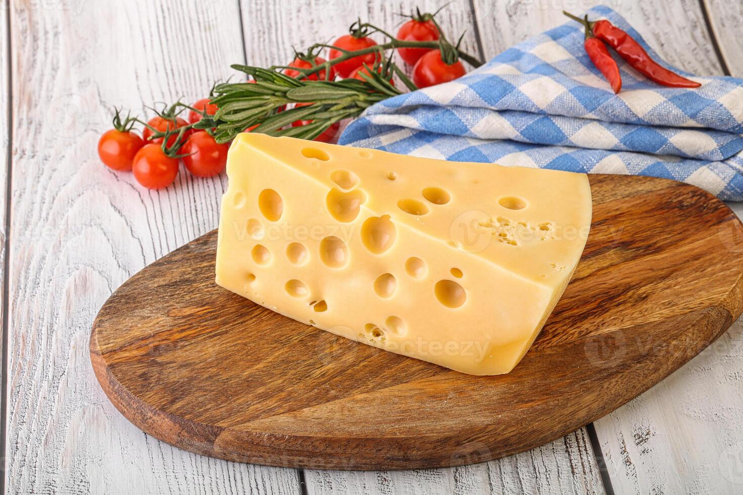 Maasdam cheese piece over board photo