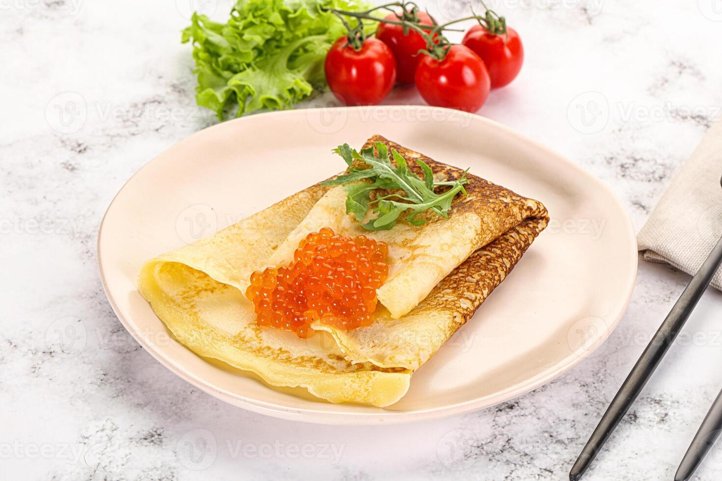 Russian pancake with red caviar photo