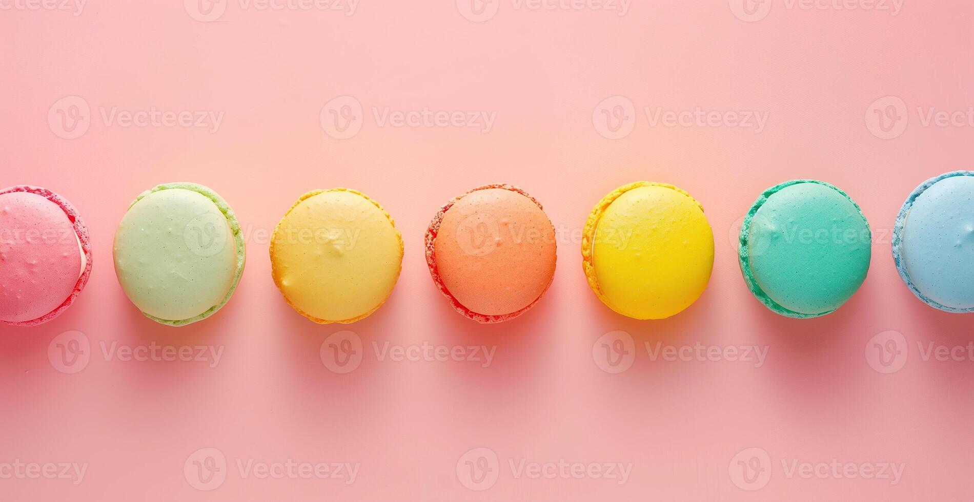 A row of colorful macarons on a pink background photo