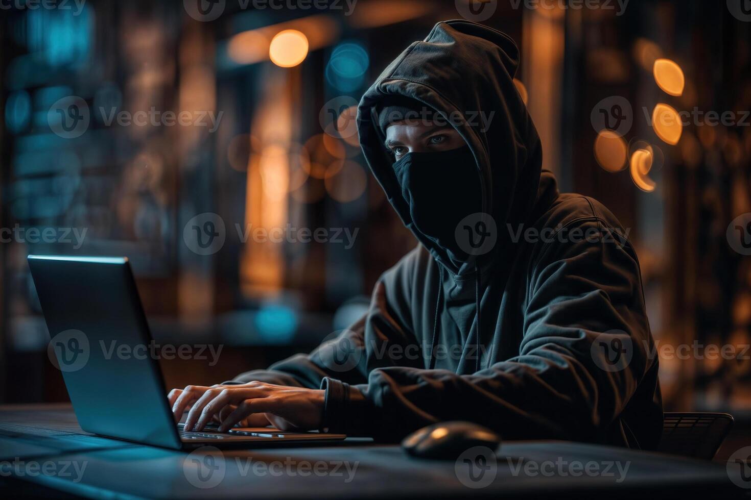 Mysterious hacker working on laptop at night photo