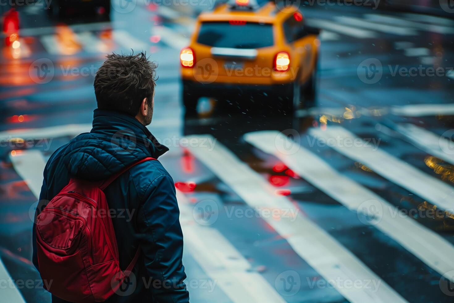 Man waiting to cross rainy city street photo