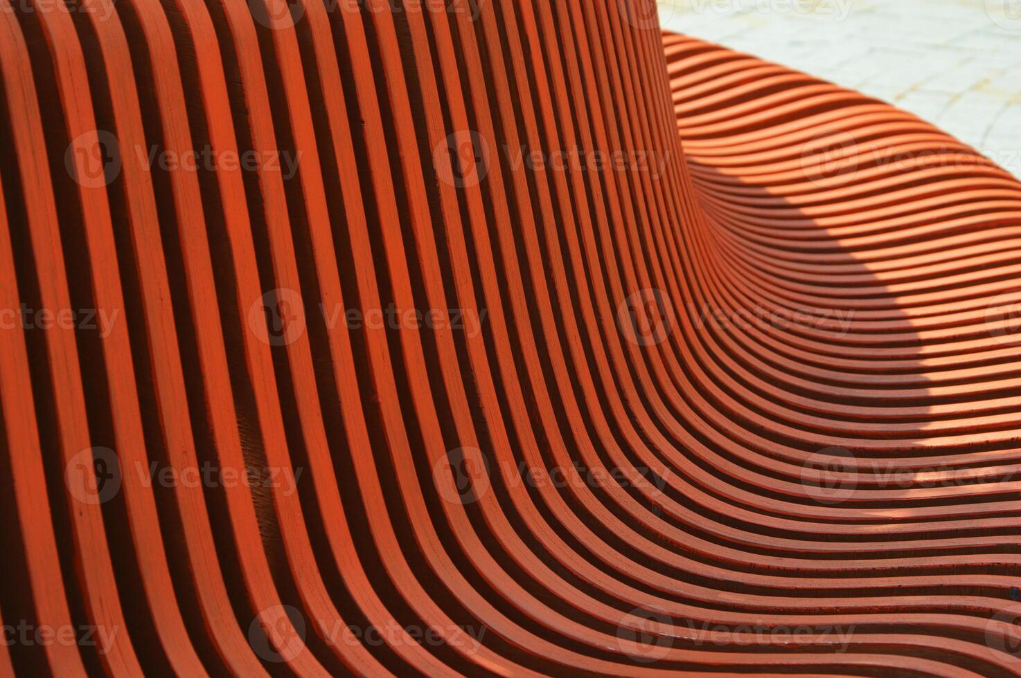 Brown wooden curved slats. Bench element, architectural design of building exterior. Abstract background. photo