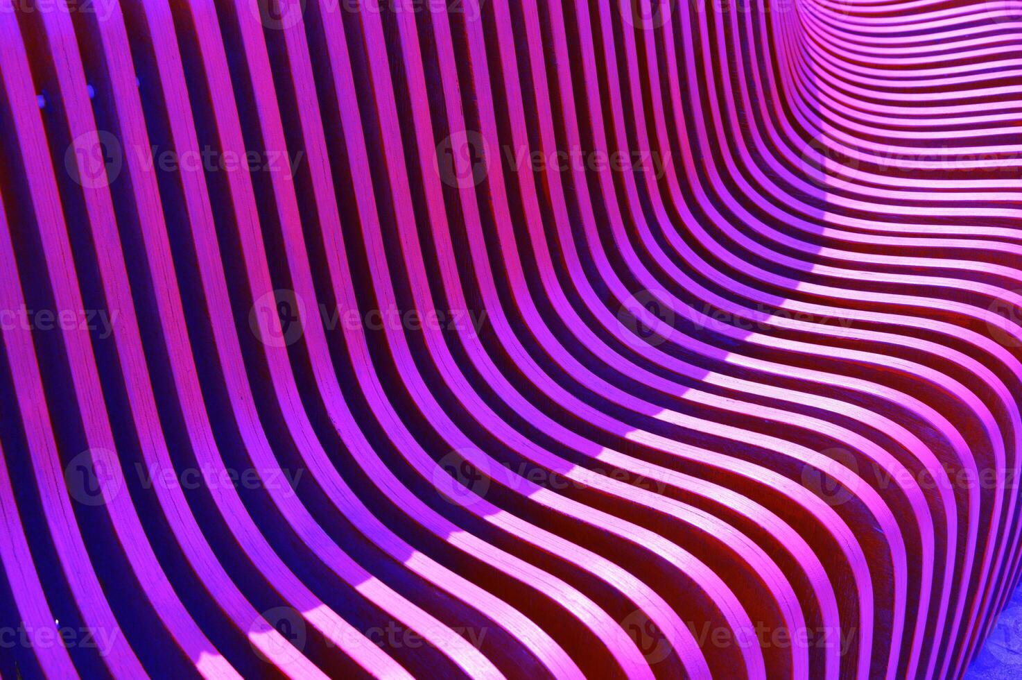 Purple pink wooden curved slats, planks, boards. Element of building facade, benches. Beautiful abstract background. photo