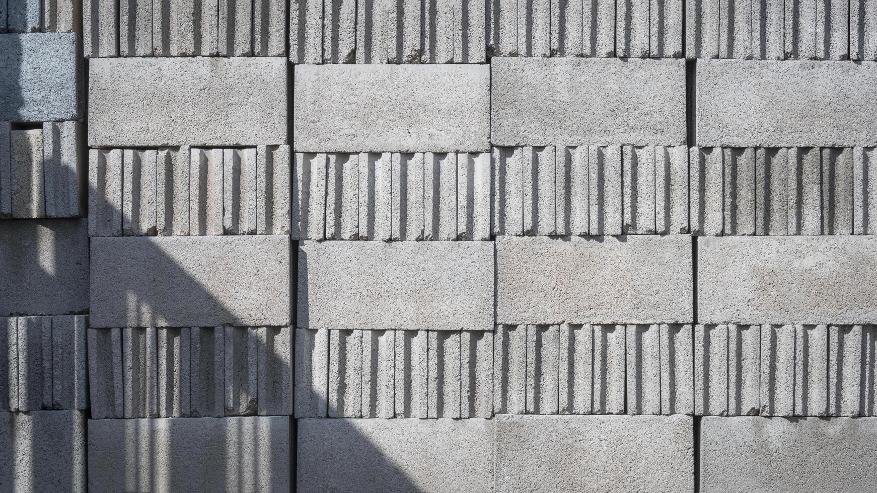 Sunlight and shadow of building structure on stack of concrete blocks surface photo