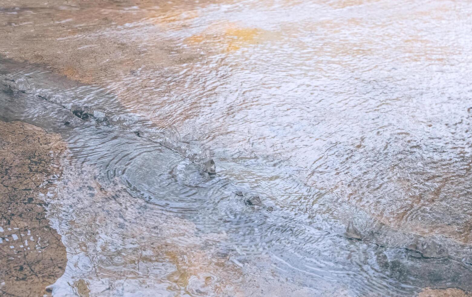 Water beneath the floor surged up through cracks of damaged concrete floor, directly above view photo