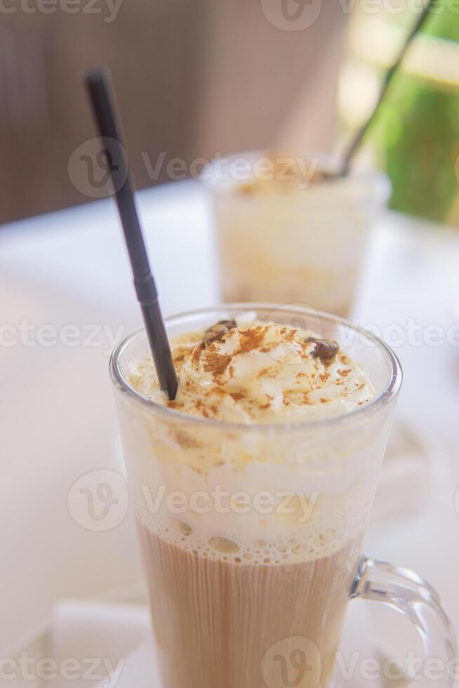 coffee is served in a tall glass glass with a straw. The concept of coffee drinks from the bar menu photo