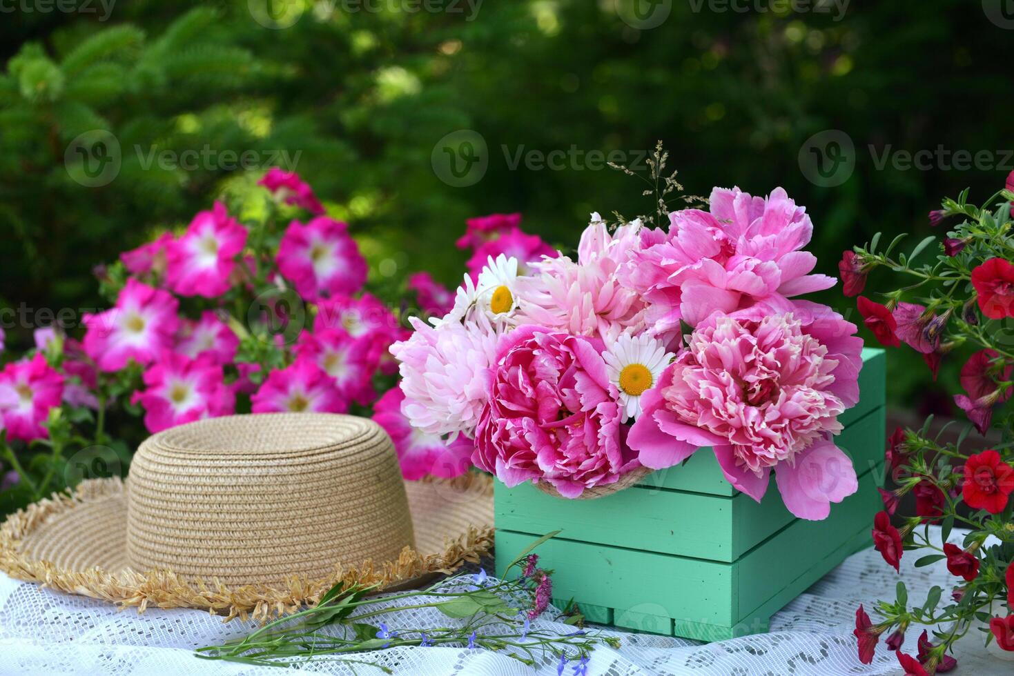 Beautiful still life with peony flowers, vintage cup and hat on the table. Romantic greeting card for birthday, Valentines, Mothers Day concept. Summer background with vintage objects photo