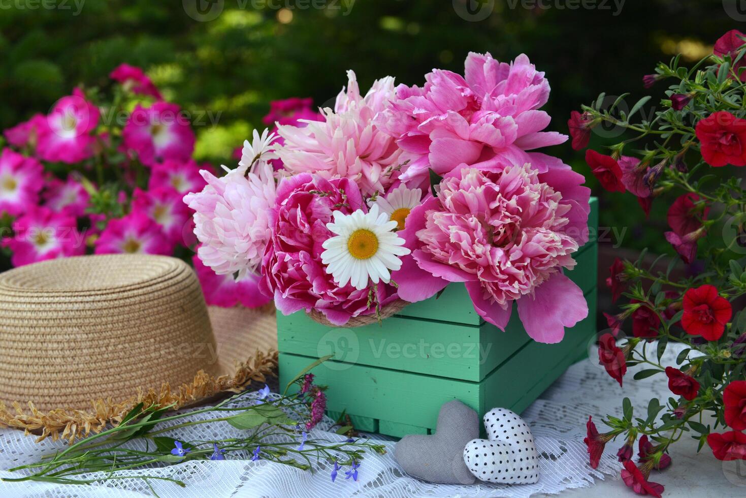 Beautiful still life with peony flowers, vintage cup and hat on the table. Romantic greeting card for birthday, Valentines, Mothers Day concept. Summer background with vintage objects photo