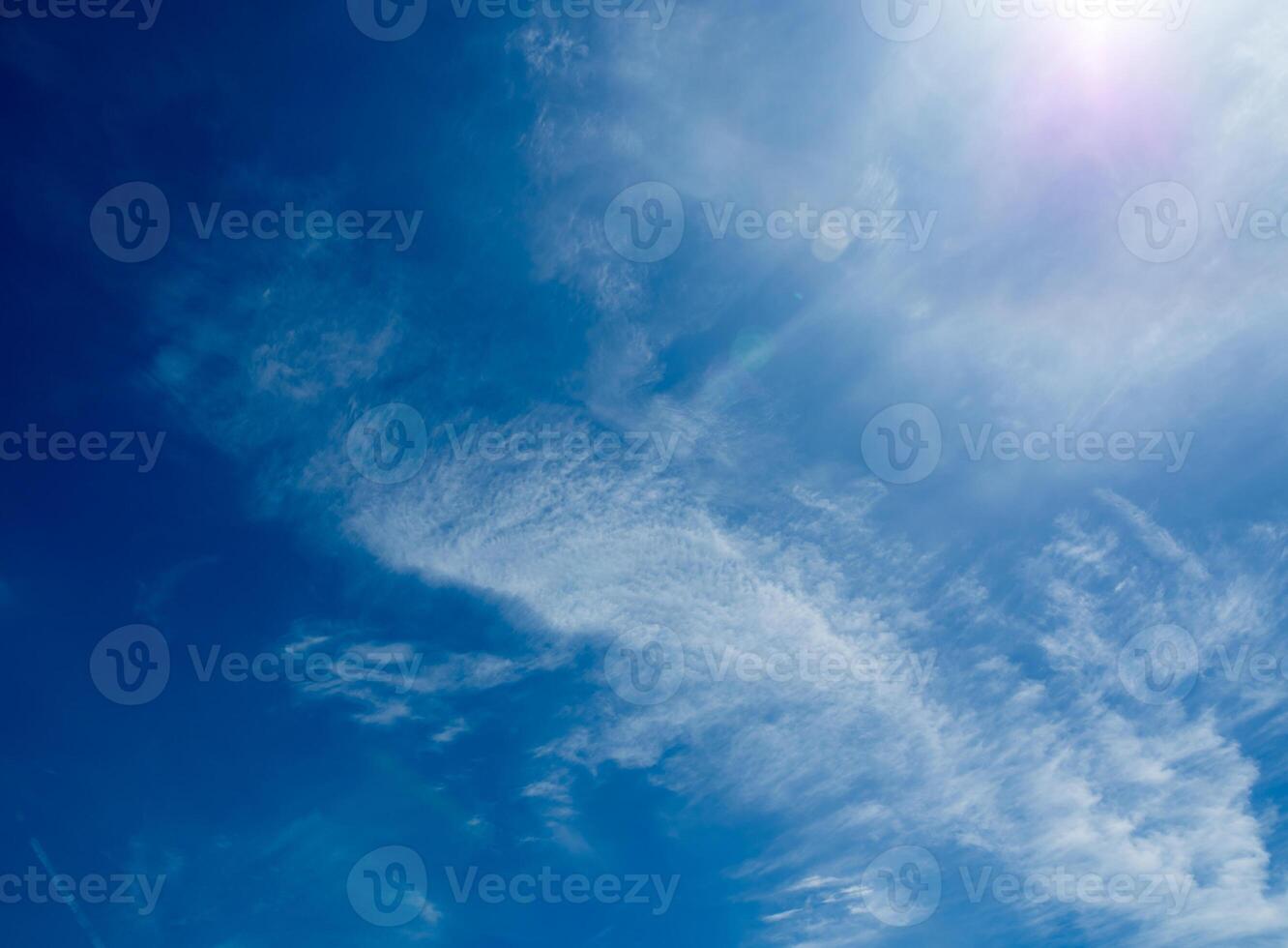 nubes blancas y esponjosas en el cielo azul brillante con la luz del sol foto