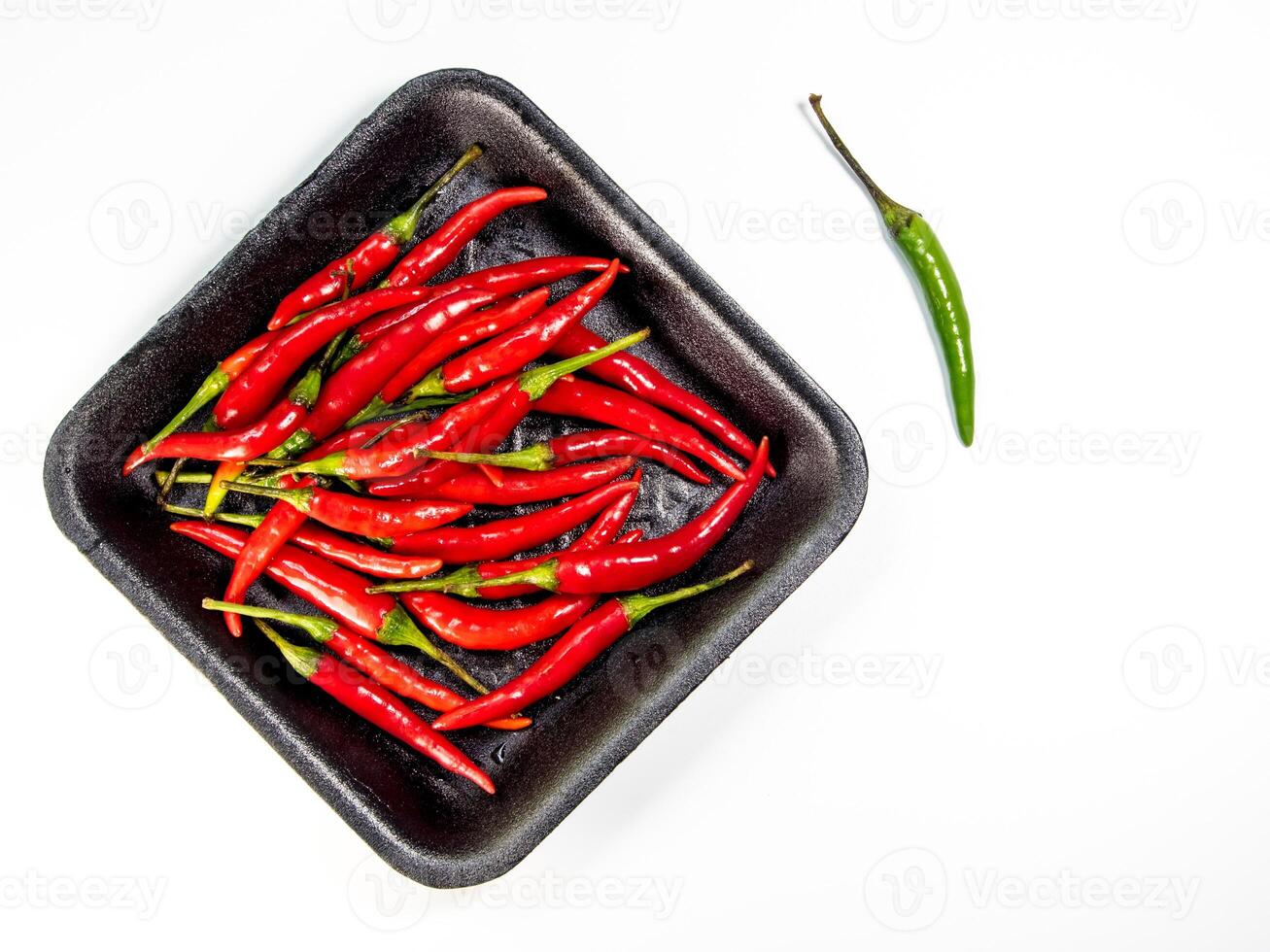 Red chili in black foam tray isolated photo