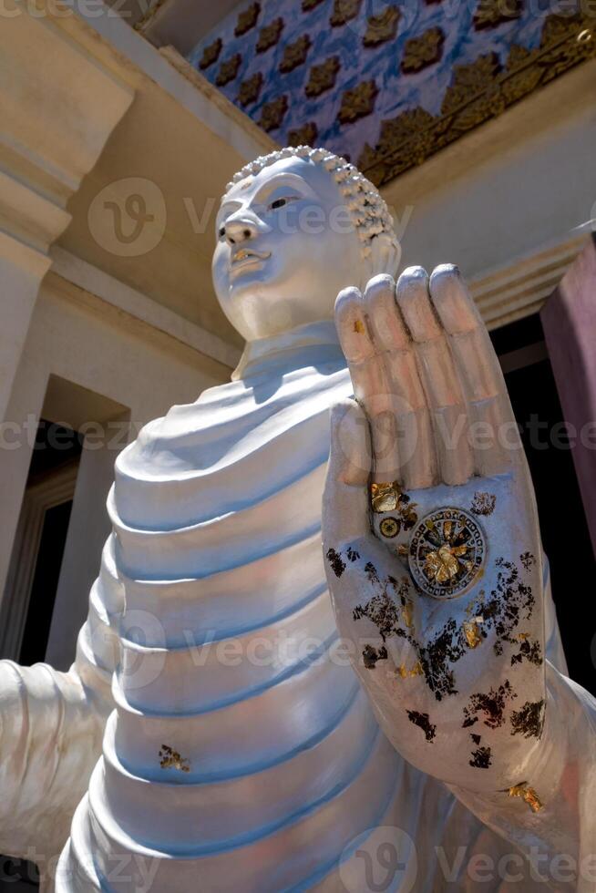 Dharmachakra symbol and gold leaf In the palm of the Buddha statue photo