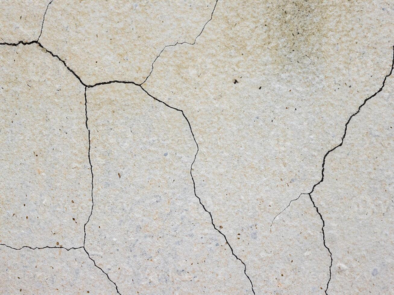 texture of a concrete wall with cracks and scratches which can be used as a background photo