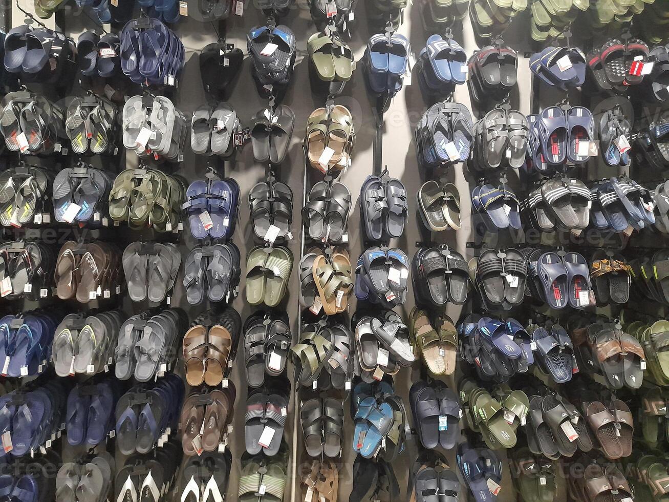 Various types of shoes and sandals displayed in a shoe shop storefront. photo