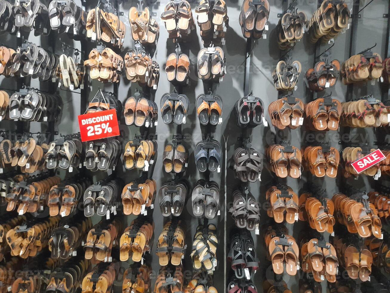 Various types of shoes and sandals displayed in a shoe shop storefront. photo