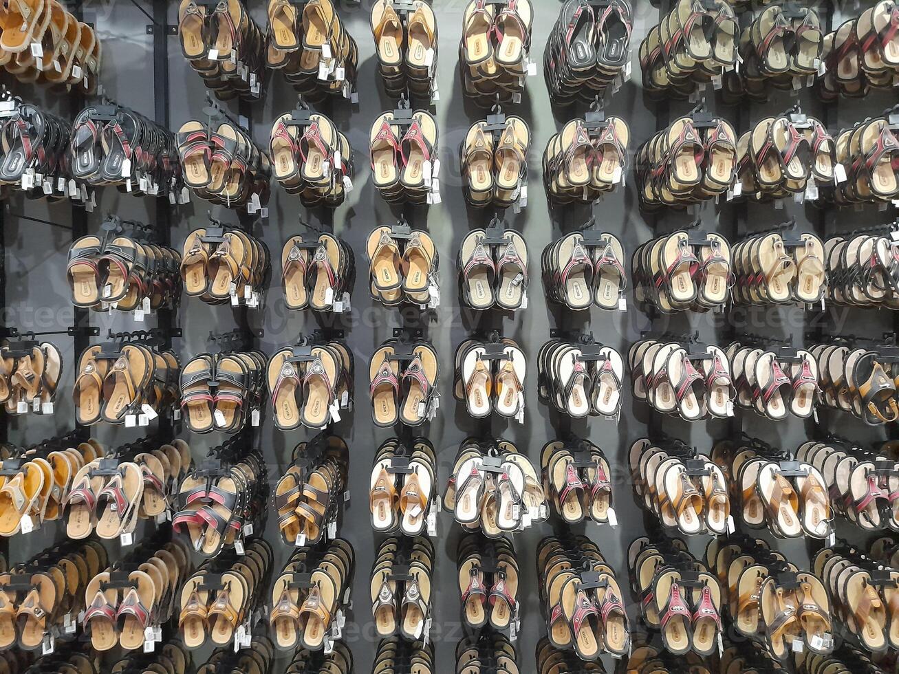 Various types of shoes and sandals displayed in a shoe shop storefront. photo