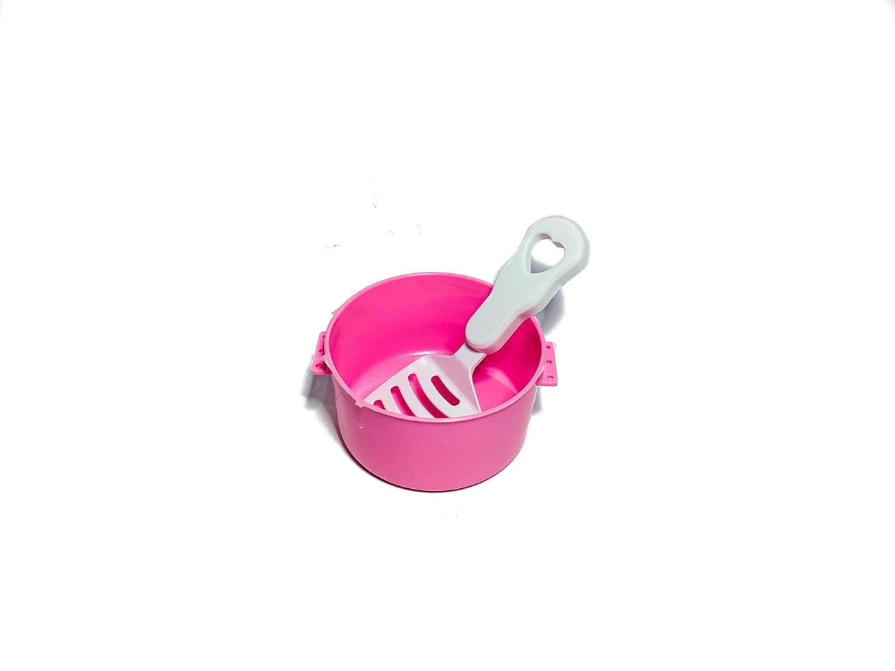 isolated image of toy pink pot and spoon. shot from the top photo