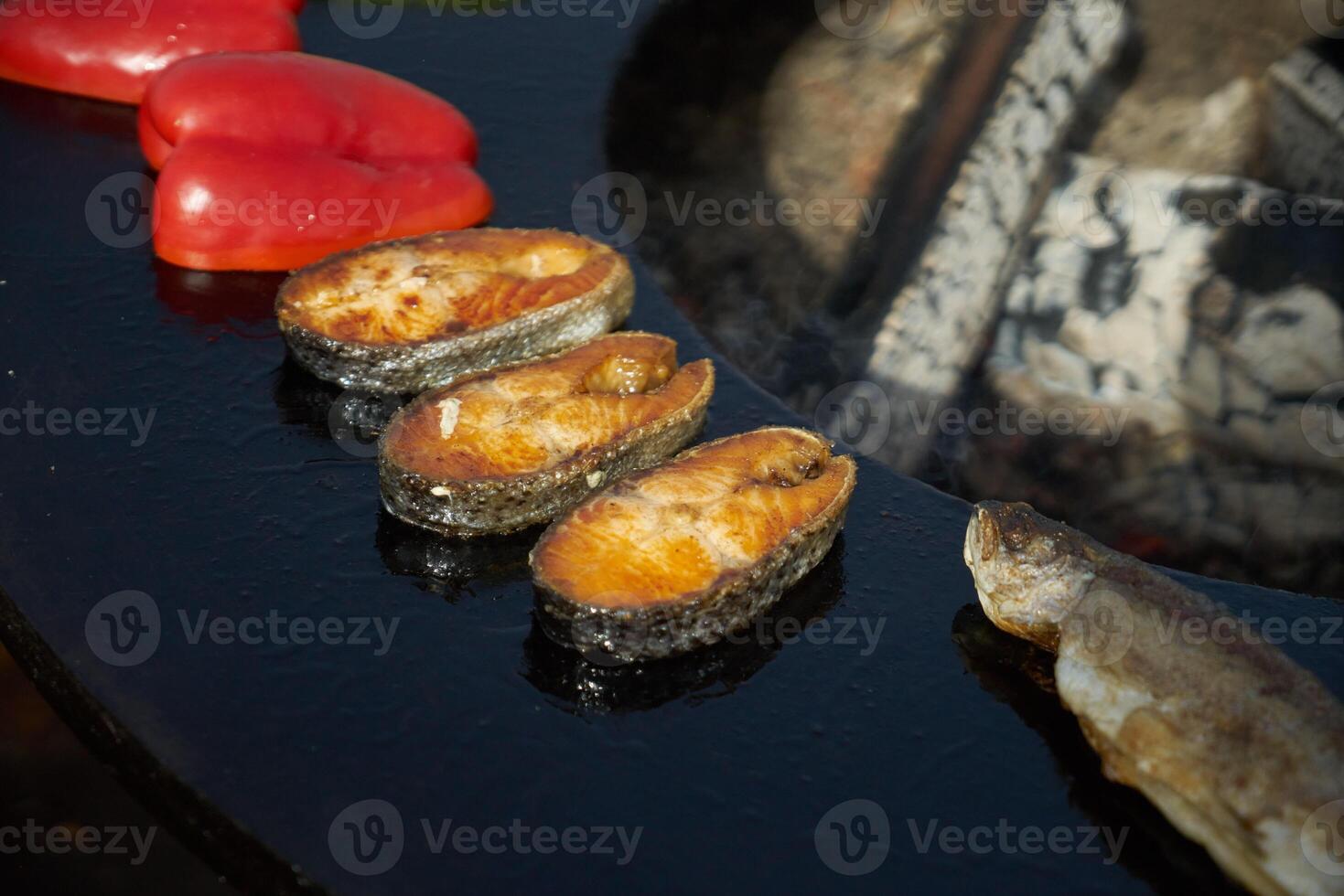 salmon steak is being cooked on the grill with an open fire photo