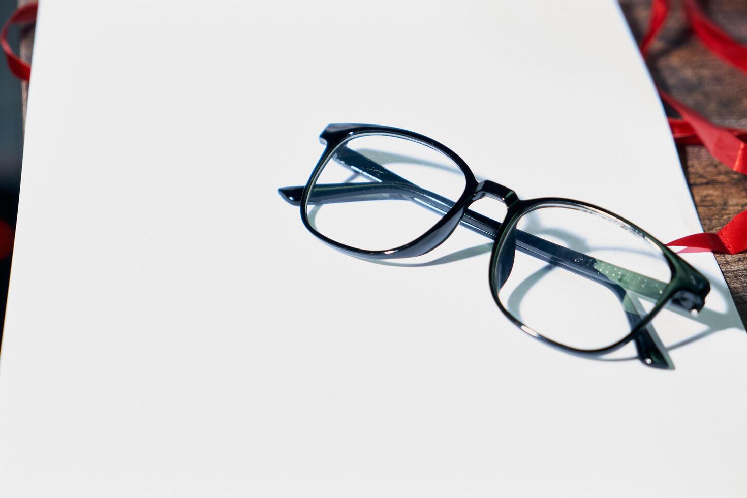 Black optical Glasses on white paper photo