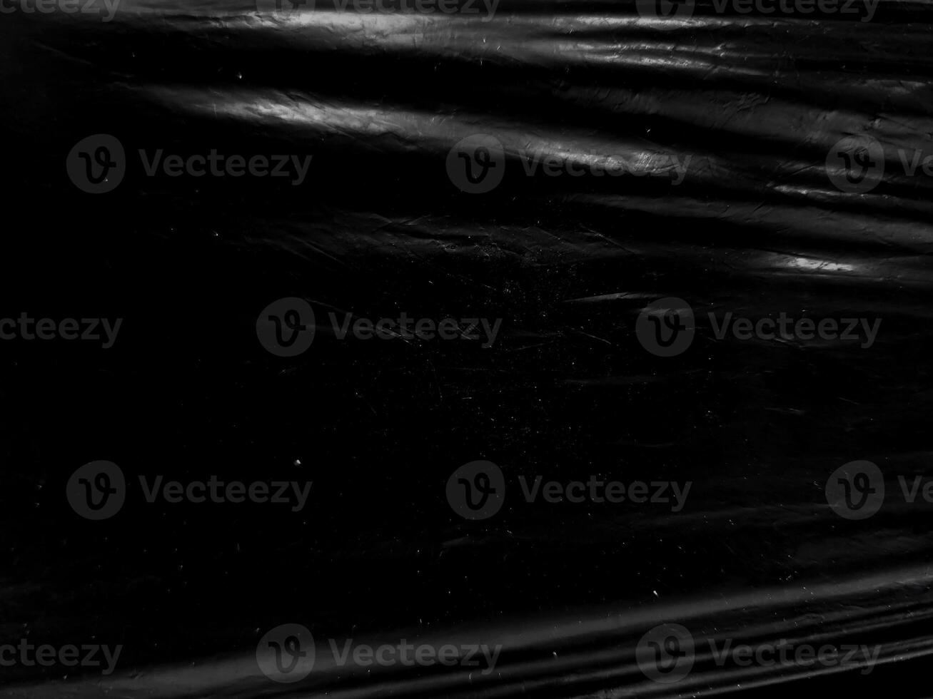 a black transparent plastic texture with hole for poster and cover art. realistic plastic wrap for overlay, copy space and photo effect. wrinkled plastic surface on black background