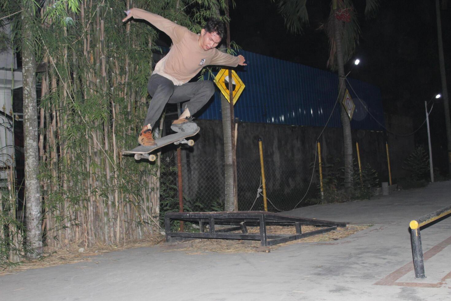 Indonesia - Medan 01 August 2023 an asian man doing skateboard tricks on a ramp photo