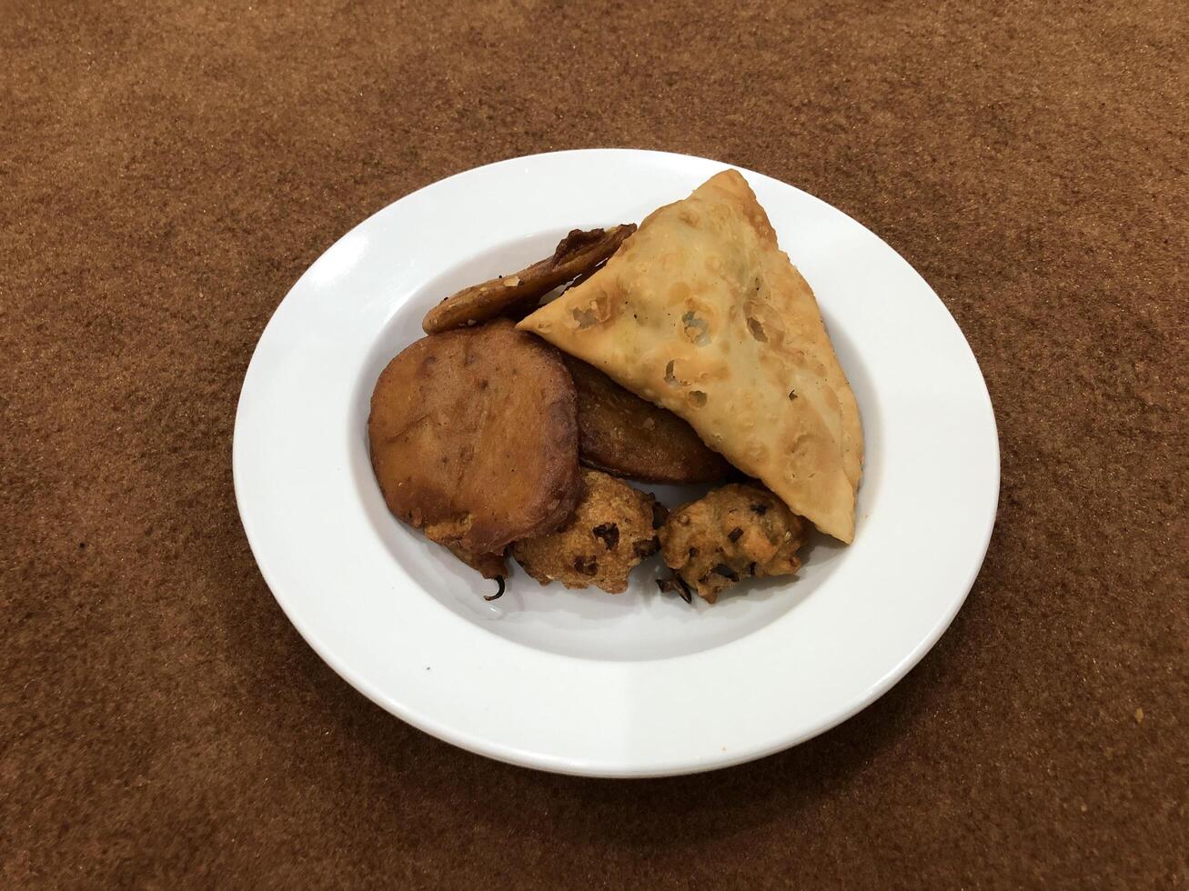 solated top view of qeema samosa and basin pakora in white plate, Popular indian or pakistani street food snack on white background, Diwali dinner or iftar meal. photo