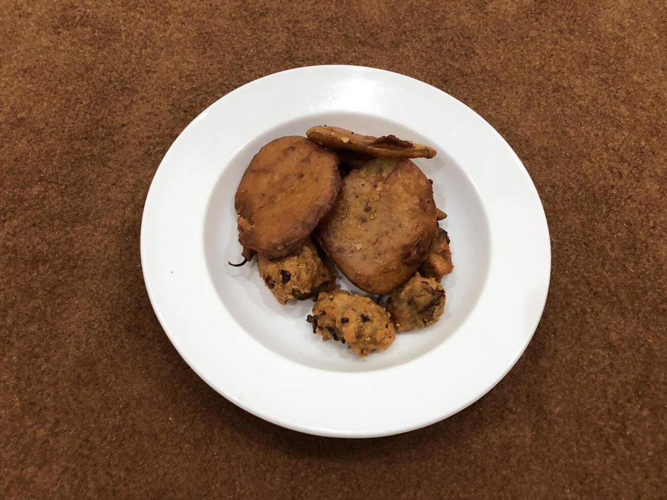 aislado cuenca pakora, popular indio o pakistaní calle comida bocadillo en blanco plato foto