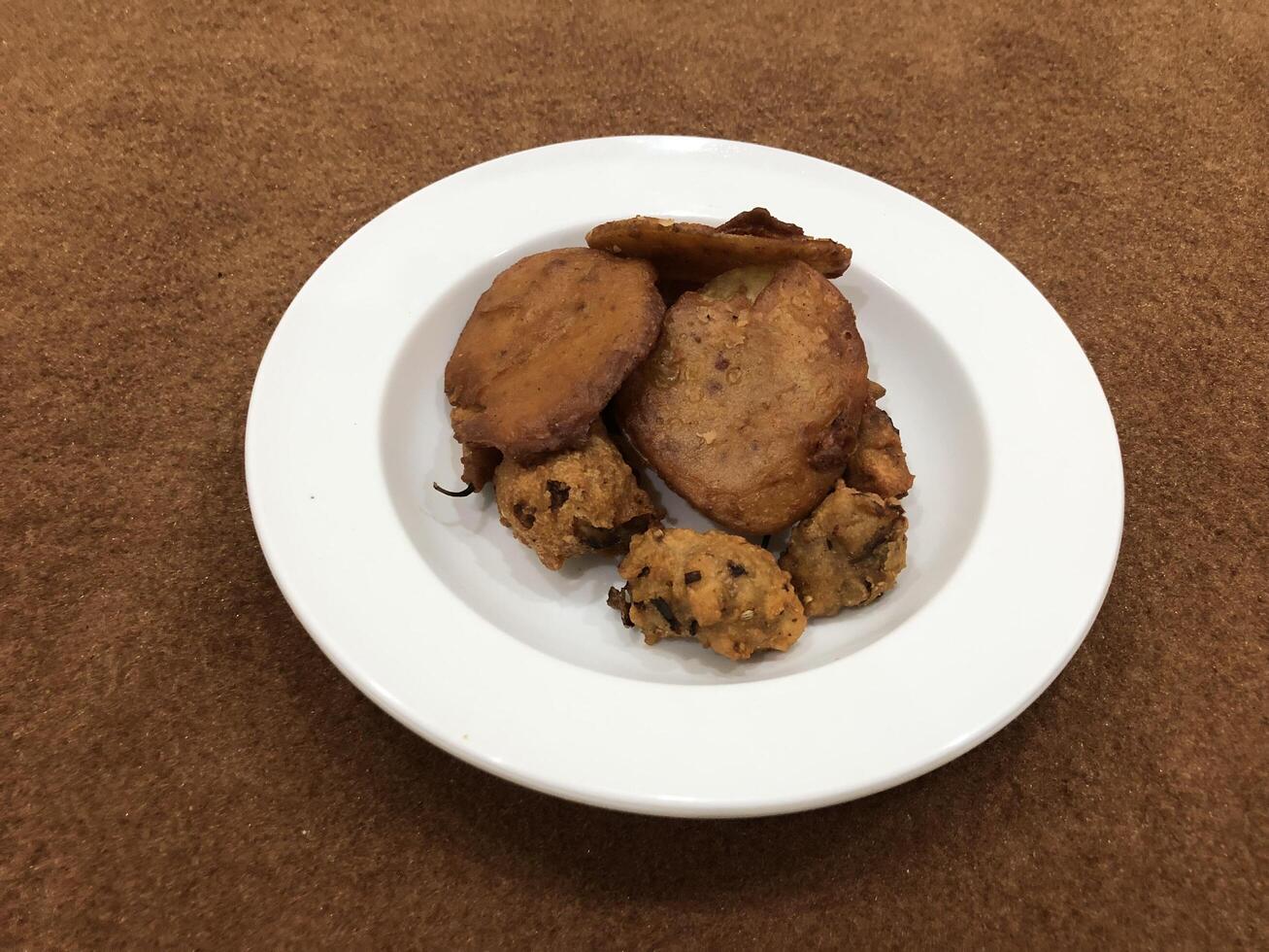 aislado cuenca pakora, popular indio o pakistaní calle comida bocadillo en blanco plato foto