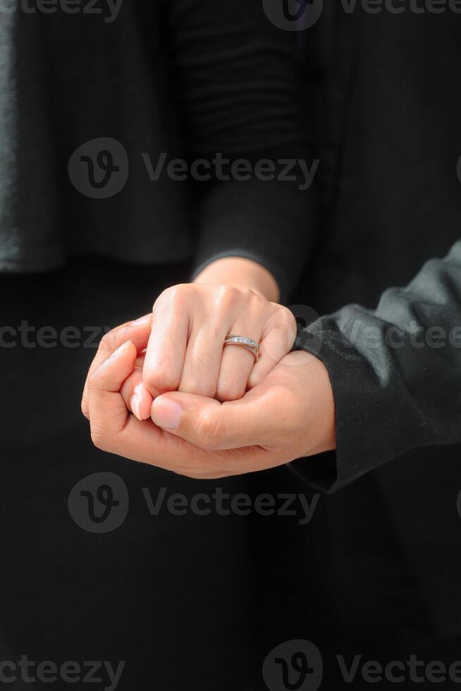 Wedding ring photo shoot concept a man wearing a formal black suit and purple tie and woman with purple suit is holding a wedding ring