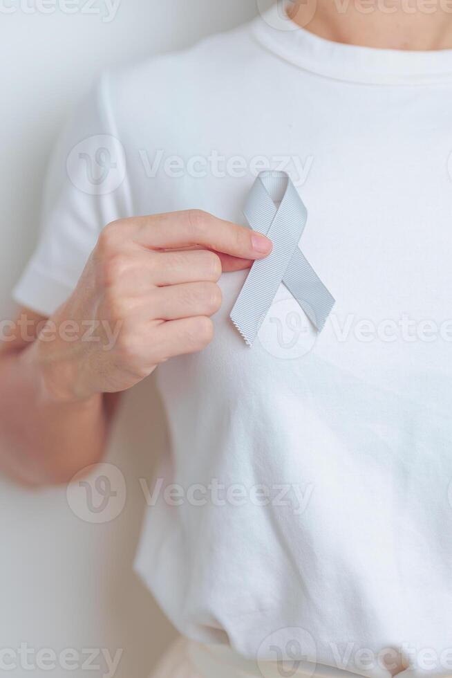 Brain Cancer Awareness May month, woman with grey color Ribbon for supporting life people. Healthcare and World cancer day concept photo