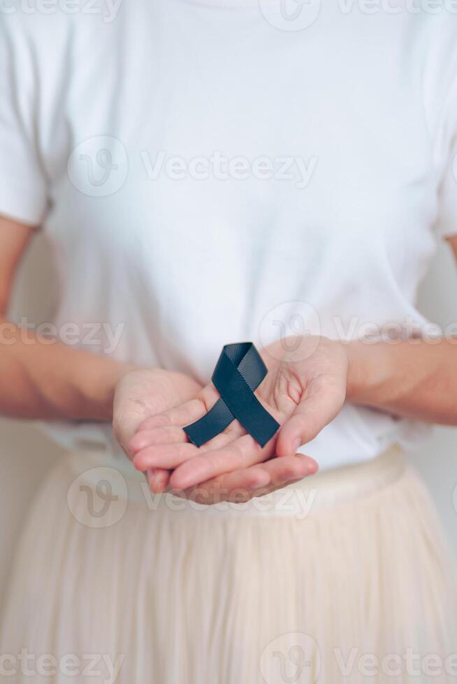 Melanoma and skin cancer, Vaccine injury awareness month and rest in peace concepts. woman holding black Ribbon photo