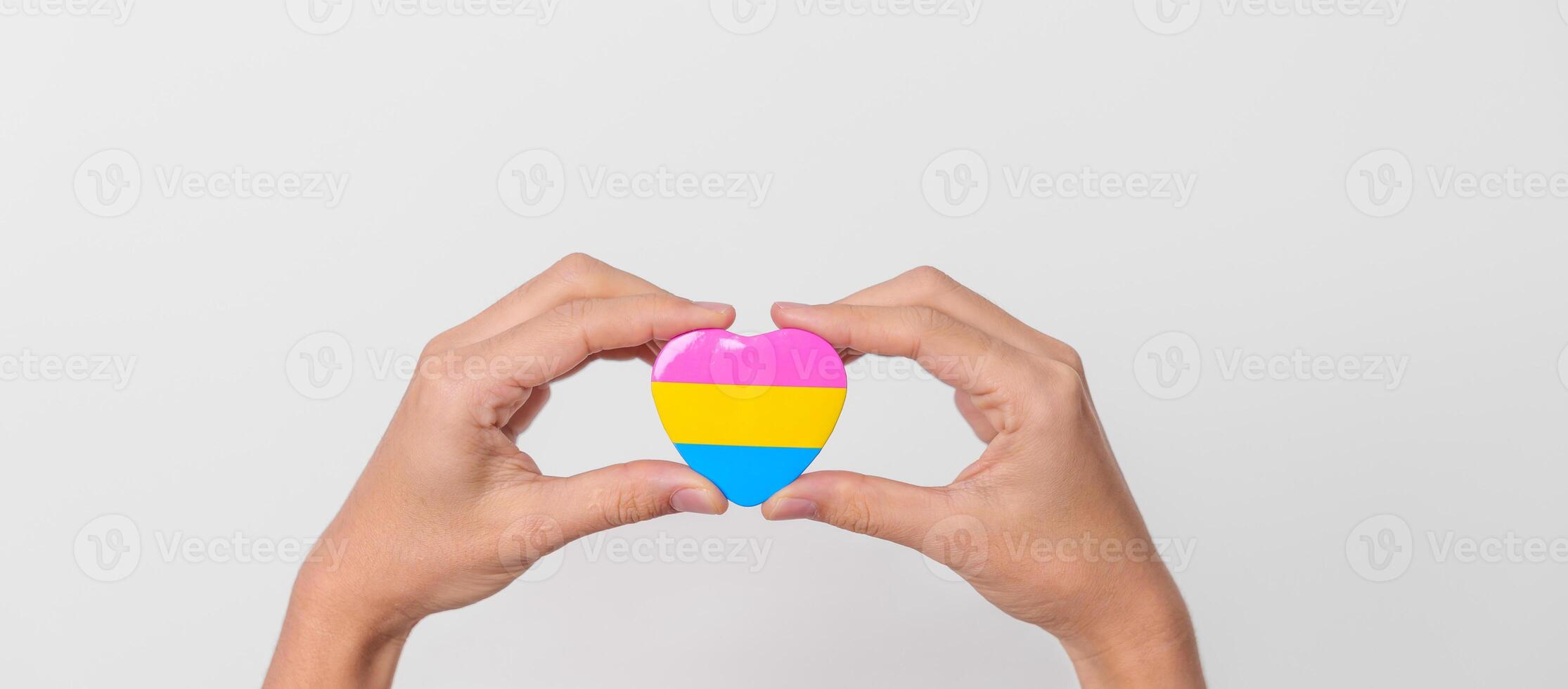 pansexual orgullo día y lgbt orgullo mes concepto. mano participación rosa, amarillo y azul corazón forma para lesbiana, homosexual, bisexual, Transgénero, queer y pansexual comunidad foto