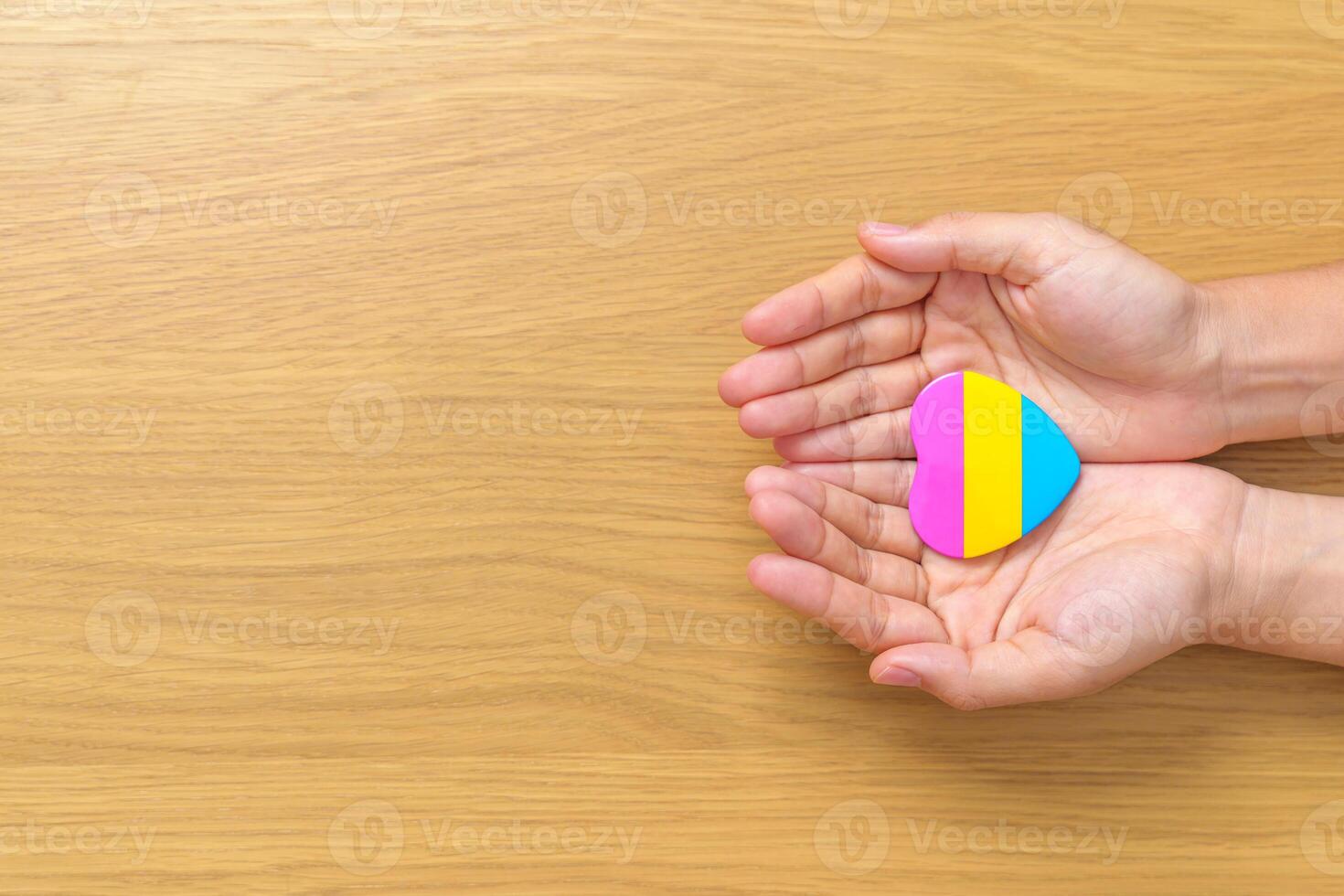 Pansexual Pride Day and LGBT pride month concept. hand holding pink, yellow and blue heart shape for Lesbian, Gay, Bisexual, Transgender, Queer and Pansexual community photo