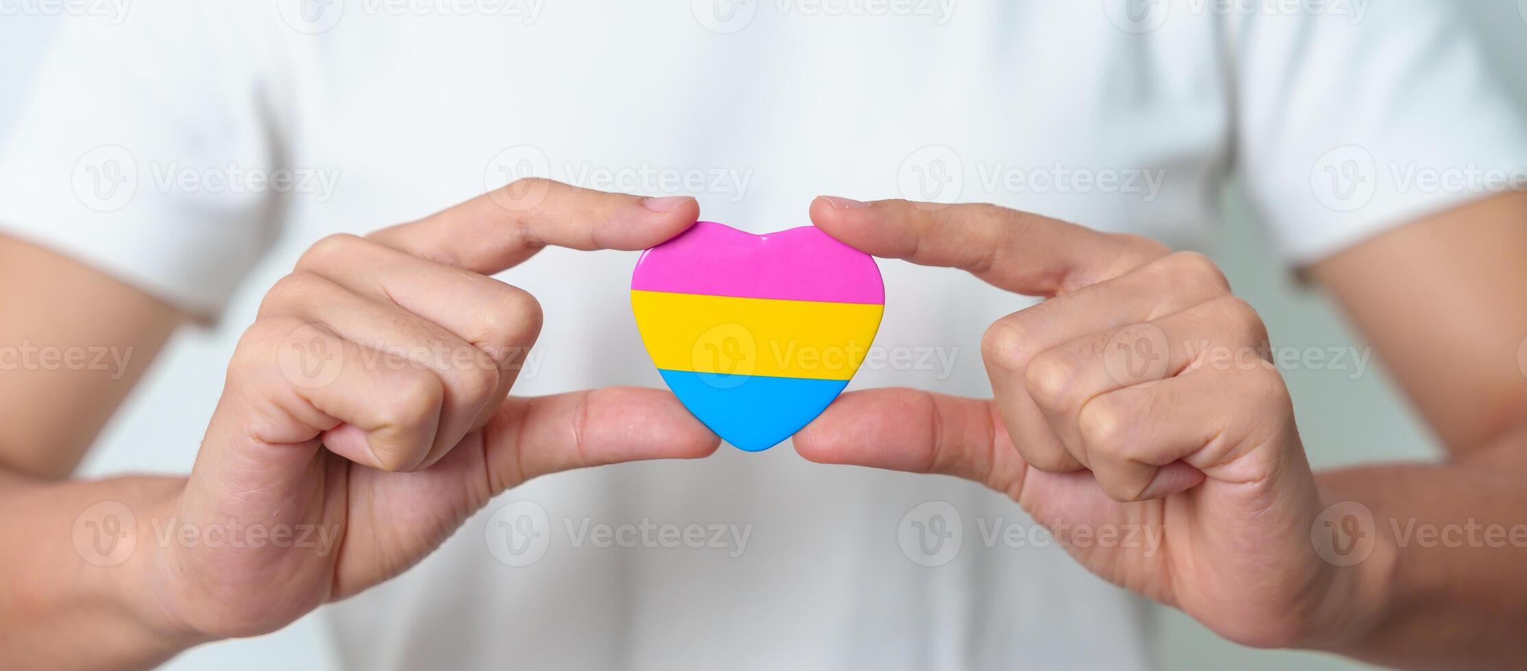 Pansexual Pride Day and LGBT pride month concept. hand holding pink, yellow and blue heart shape for Lesbian, Gay, Bisexual, Transgender, Queer and Pansexual community photo