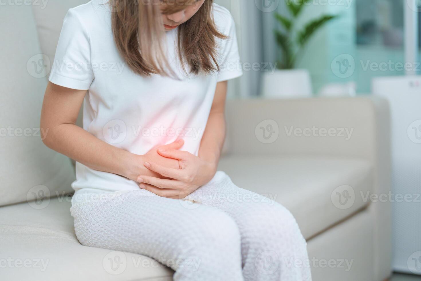 woman having abdomen ache due to Stomach pain, digestion with constipation or Diarrhea from food poisoning, female problem and Endometriosis, Hysterectomy, Stomachache and Menstrual on sofa at home photo