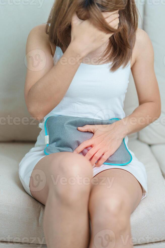 Menstruation period cycle of monthly and Stomachache concepts. woman having abdomen pain and menstrual ache with hot water bottle, illness female suffer from premenstrual ache and body Health problem photo