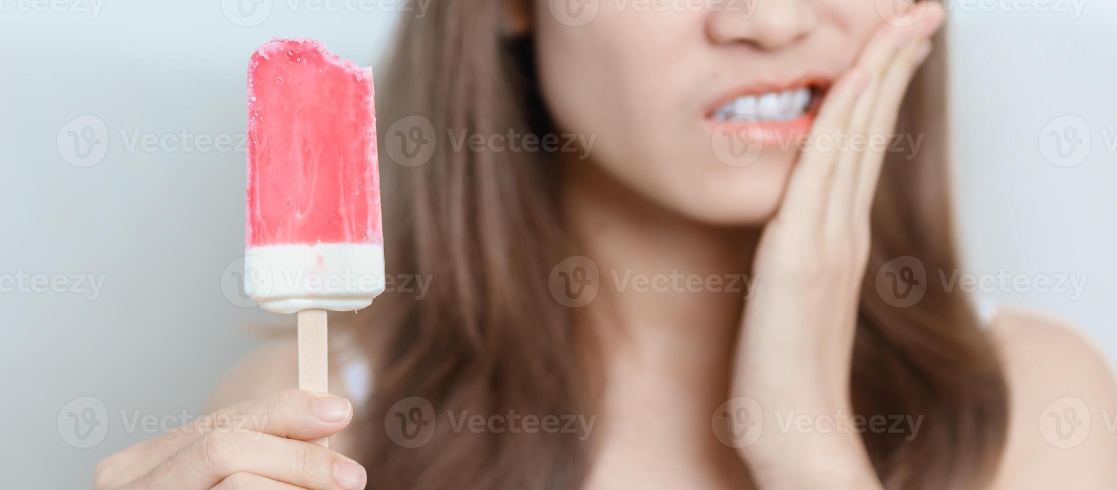 Teeth Sensitive to Cold concept. woman hold Ice cream and having toothache and pain after eat. Tooth Decay or Gum Disease, Grinding Teeth and Stress, Exposed Nerve Roots, Crack and Receding Gums photo