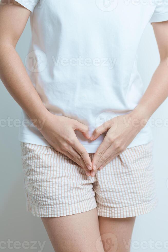 Woman hand heart shape over abdomen. Ovarian and Cervical cancer, Endometriosis, Hysterectomy, Uterine fibroids, Reproductive, menstruation, Stomach, Pregnancy and Sexual Transmitted disease concept photo