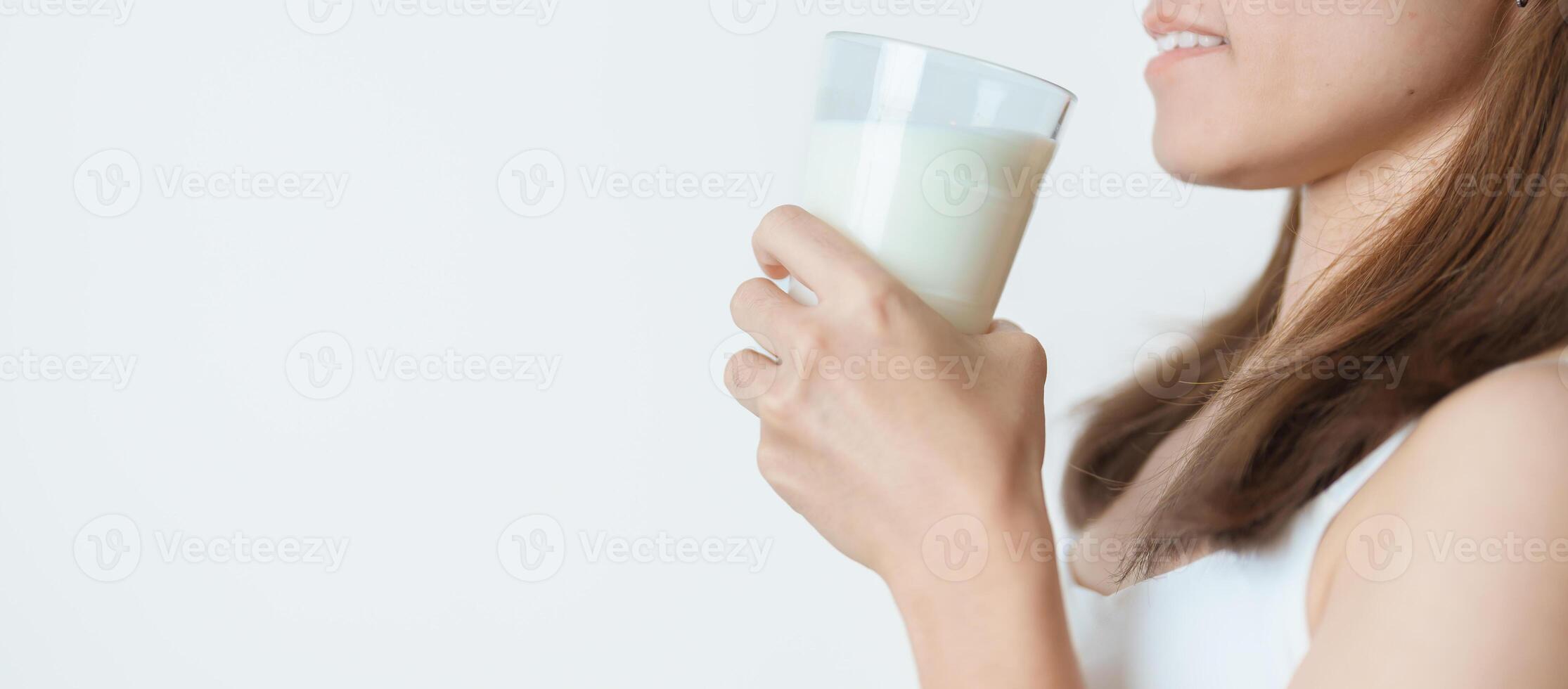 Milk drink and Daily Routine concept. Young woman Drinking milk with high calcium and nutrition at home, woman holding soy milk on glass with protein. Healthy, wellness and happy lifestyle photo